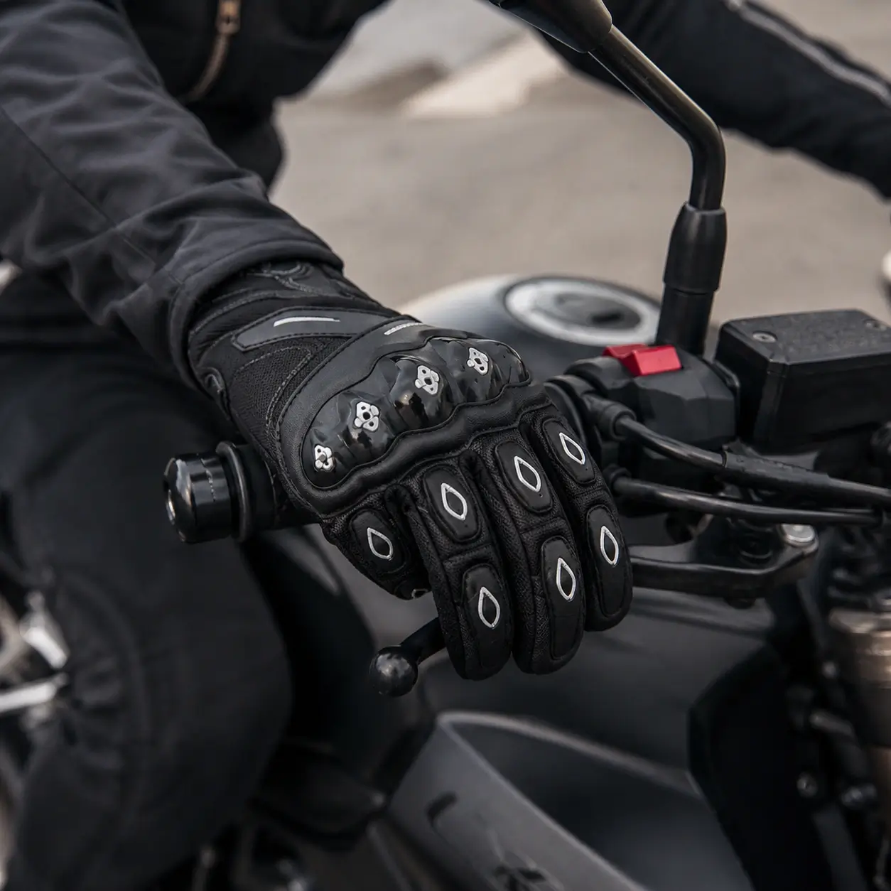 Guantes para moto SCOYCO MC10 en uso durante conducción, con agarre en manillar y ajuste en muñeca