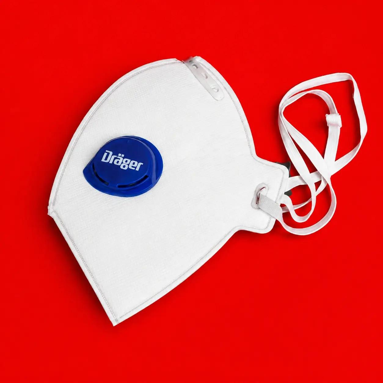 Respirador FFP3 con válvula Dräger visto de frente sobre fondo rojo para protección respiratoria industrial