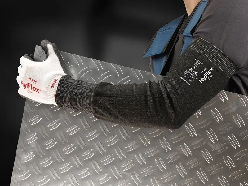 Trabajador con manga anticorte para brazos Ansell HyFlex 11-250 manipulando una lámina metálica